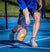 A pickleball player hits a low volley shot. 