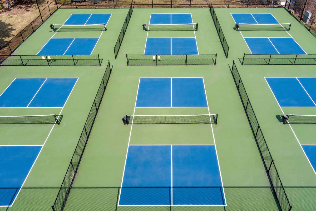 Aerial view of a pickleball complex featuring several geometric courts 